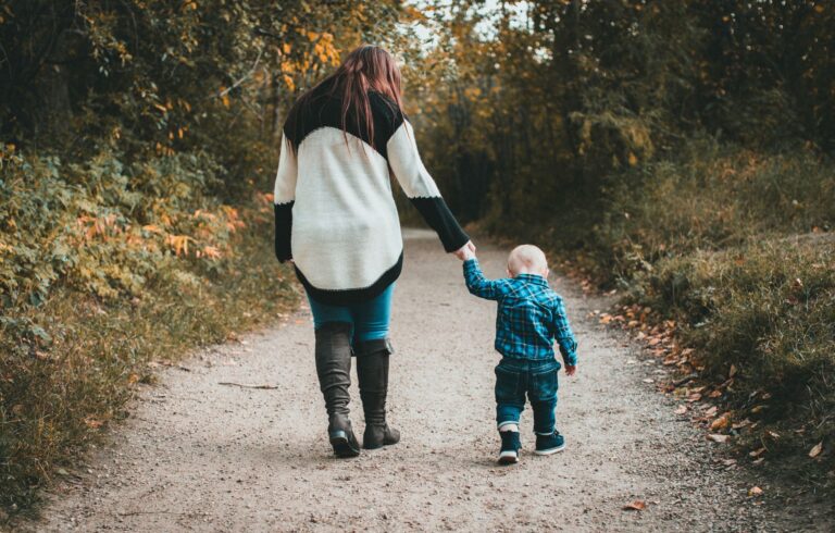 Mãe e filho caminhando pela trilha na floresta