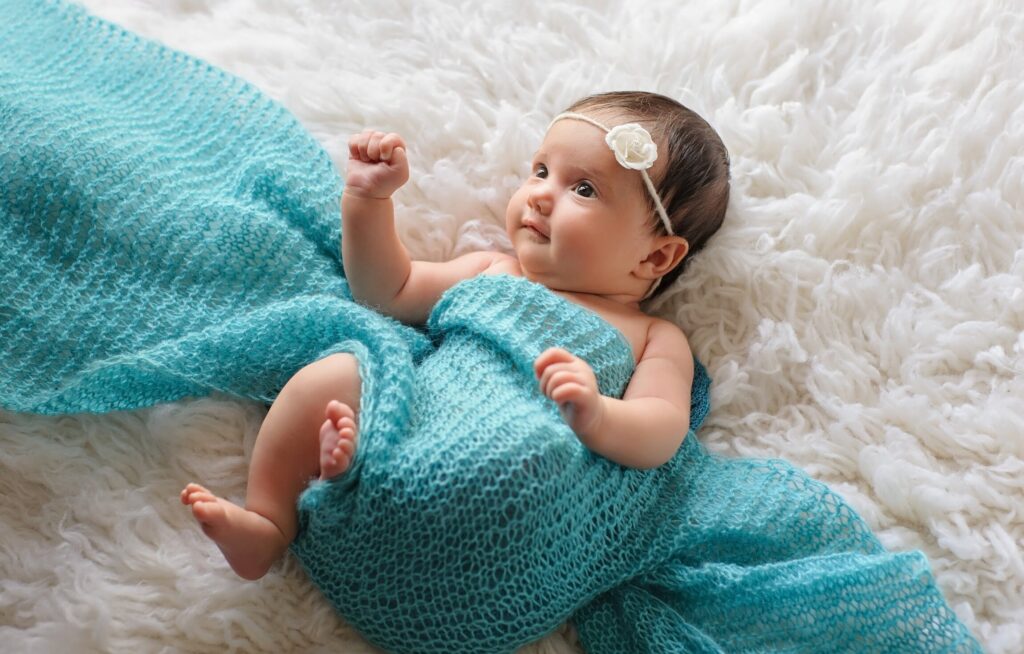 Bebê com pano azul em fundo fofo