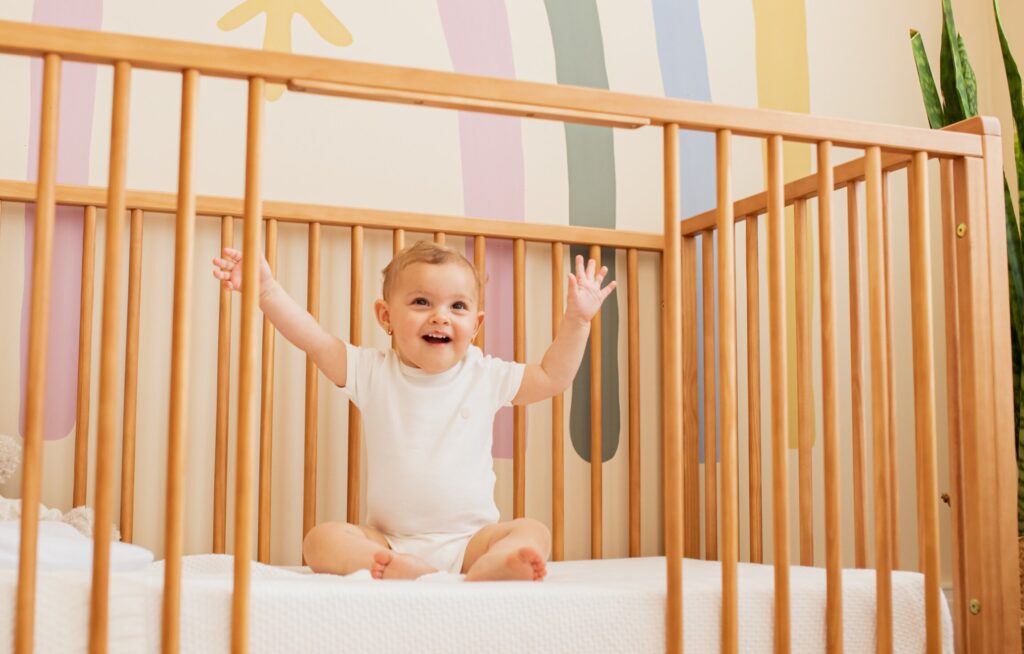 23b72fac nomes de menina1 Bebê sorridente em berço de madeira