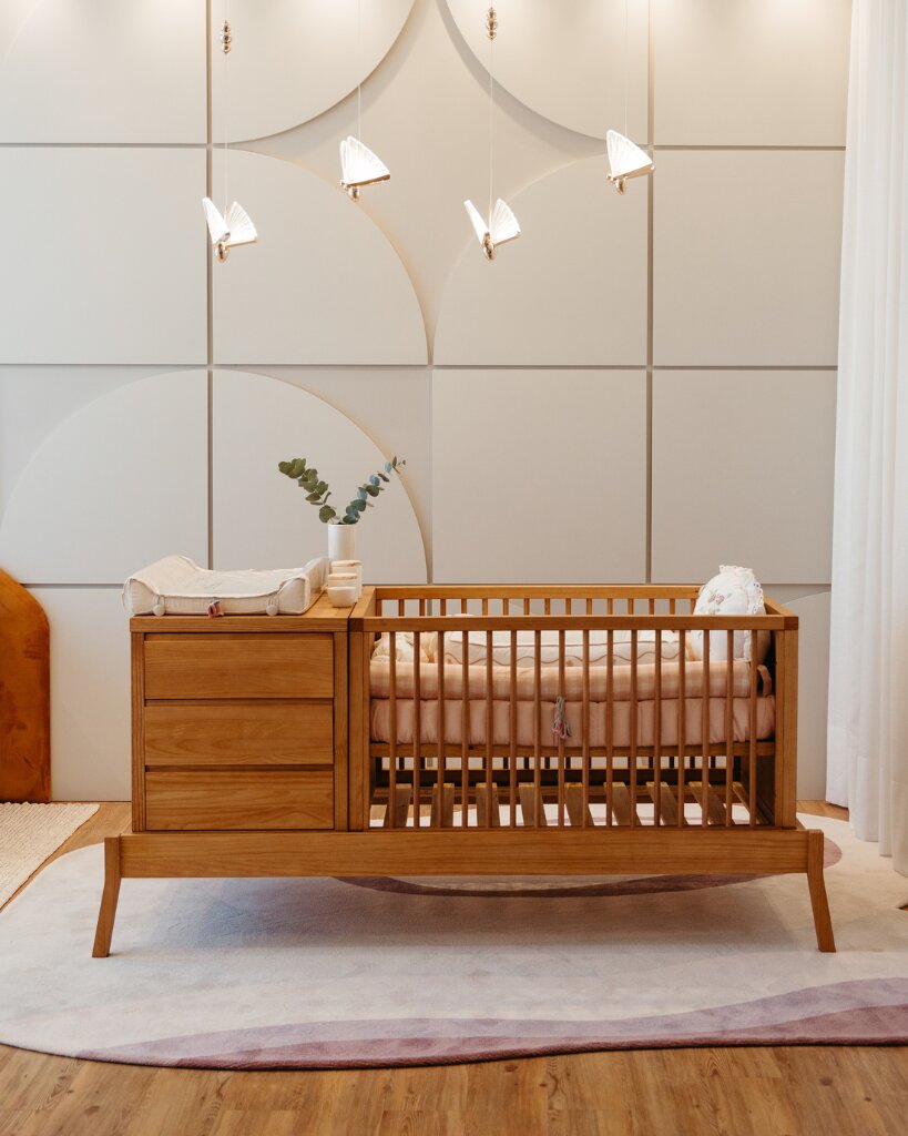 Cômoda e berço de madeira em ambiente decorado