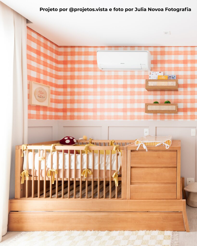 Quarto de bebê com berço de madeira e parede quadriculada